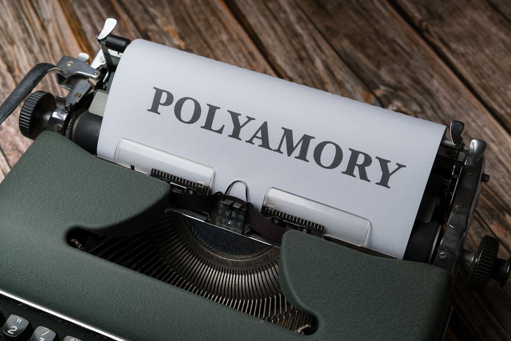 Blog Updates Daily A classic typewriter displaying the word 'Polyamory' on wooden background.