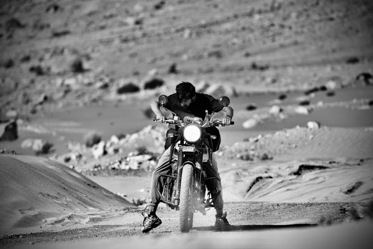 Provascin Why Darundar Is Banned in India A daring motorcyclist navigates through the challenging sandy terrain of Leh in a dynamic monochrome scene.