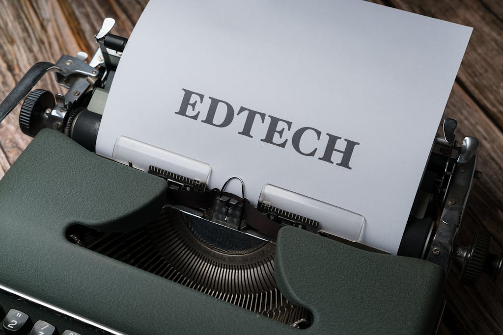 Dainikshiksha.com A classic typewriter with a sheet of paper displaying the word 'EDTECH.'