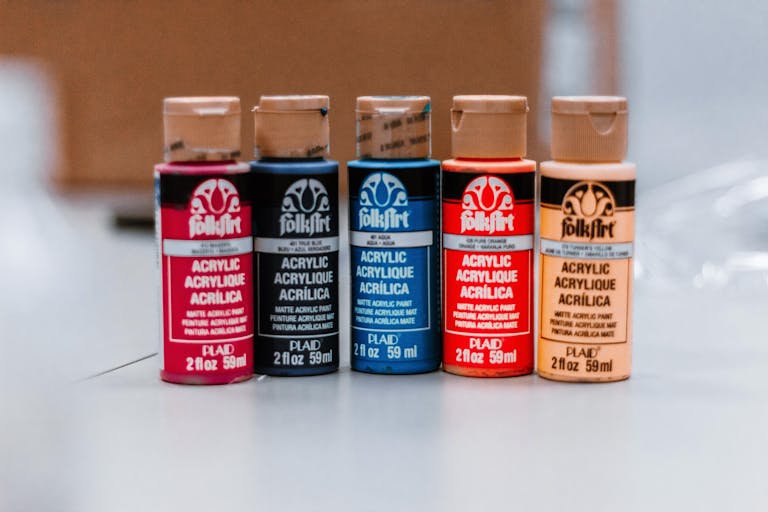 Akrylika A close-up of colorful acrylic paint bottles in varied shades, ideal for art projects.