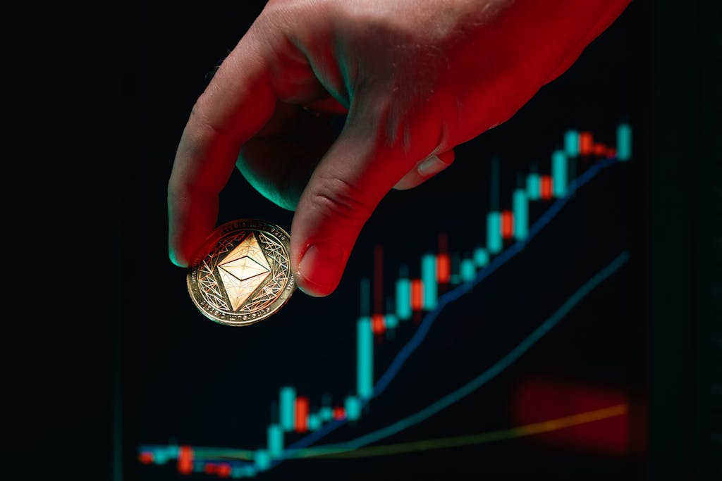 aiotechnical.com A hand holding an Ethereum coin against a rising stock market graph, symbolizing cryptocurrency growth.