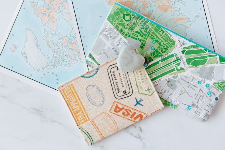 Bitni Spirs An overhead view of a passport holder on top of maps, symbolizing travel and exploration.