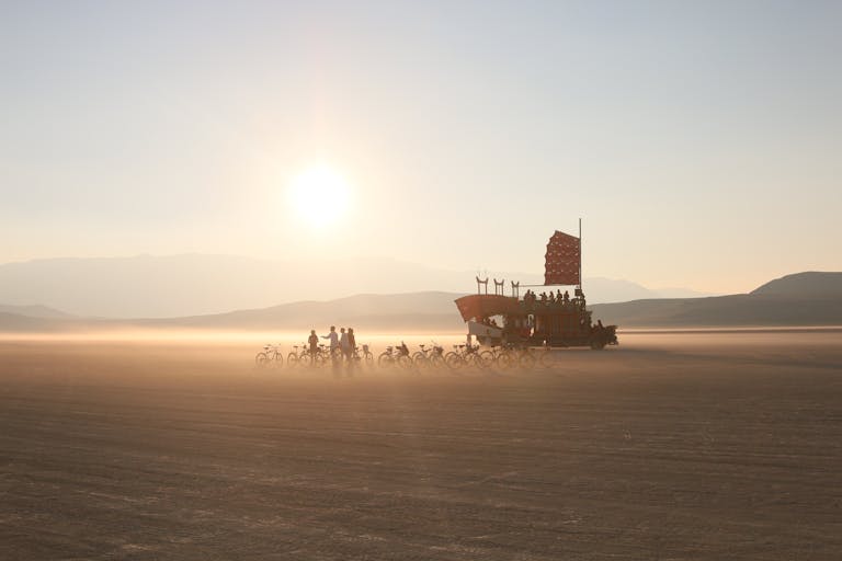 Latest News Today Bikers ride alongside a unique art car at sunrise in the Nevada desert.