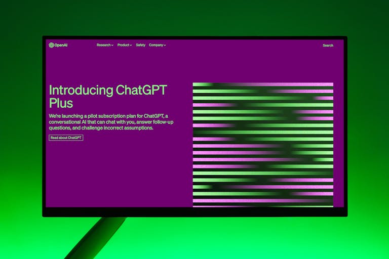 aiotechnical.com Close-up of a monitor displaying ChatGPT Plus introduction on a green background.