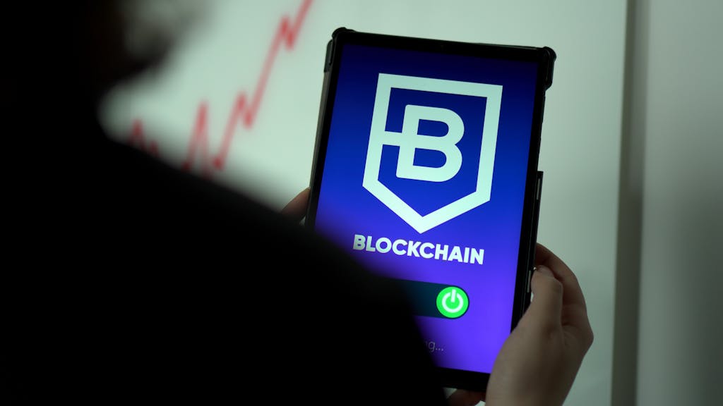 i square – Lenovo Ex Close-up of hands holding a tablet with blockchain logo on screen, indicating crypto technology.