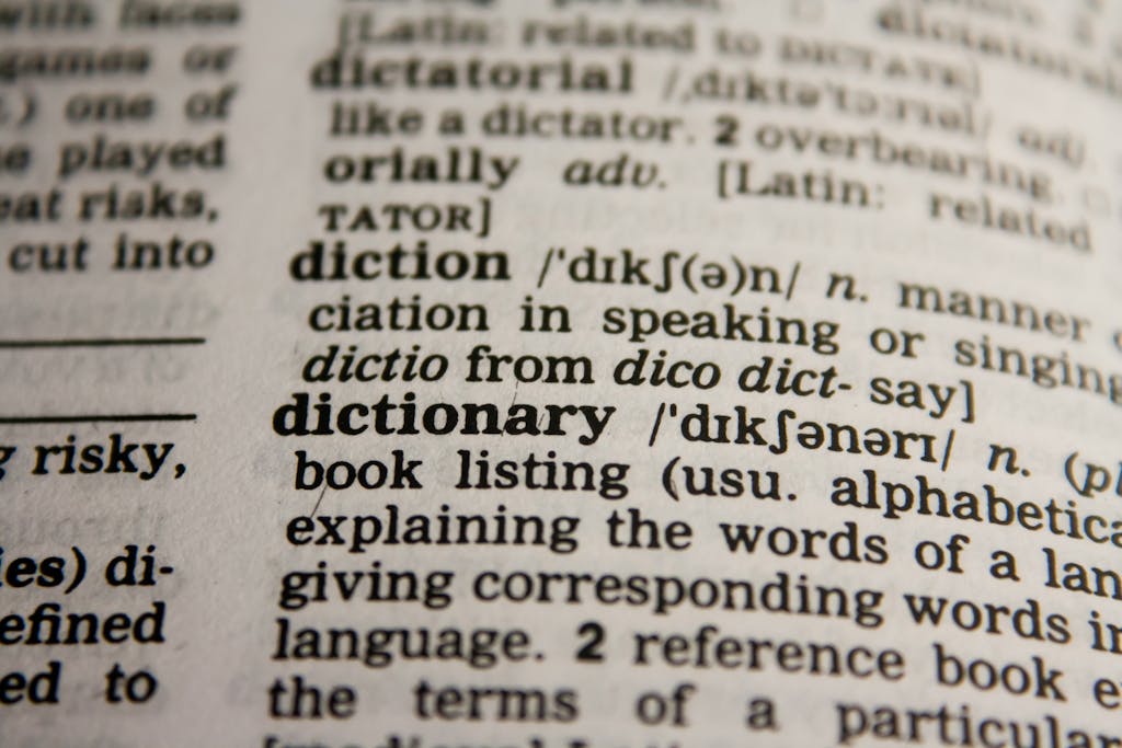 uyç Detailed close-up view of a dictionary page highlighting the word 'dictionary' and its definition.
