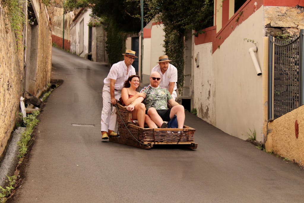 BinusCX Tourists enjoying a classic toboggan ride down the steep streets of Funchal, Madeira.