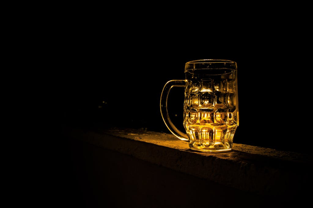 sodiceram A glass beer mug illuminated against a dark background, creating a moody atmosphere.