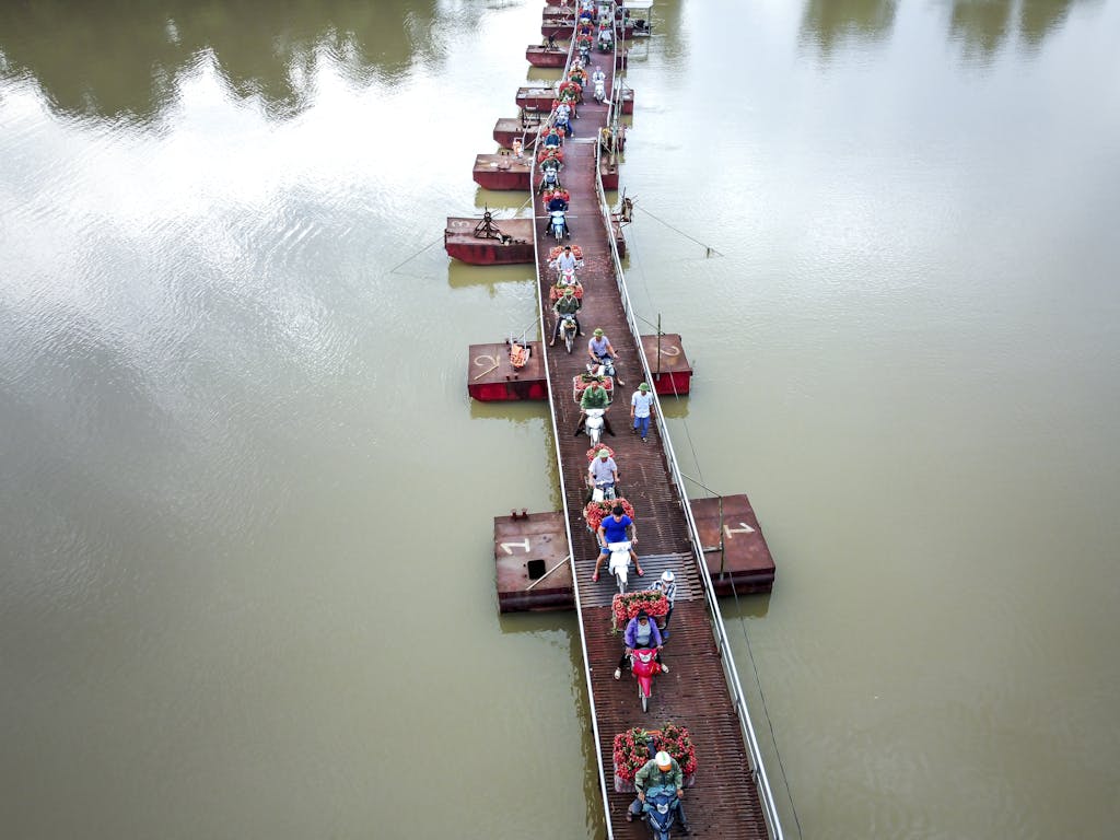 bac stock Aerial shot of motorcycles on the Tong Lanh pontoon bridge in Vietnam, showcasing daily transportation.