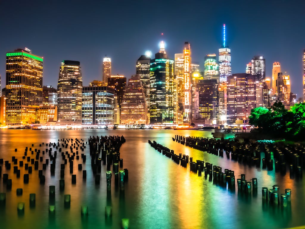 Together Toward 
Captivating night panorama of New York City skyline with vibrant city lights reflecting on the river.