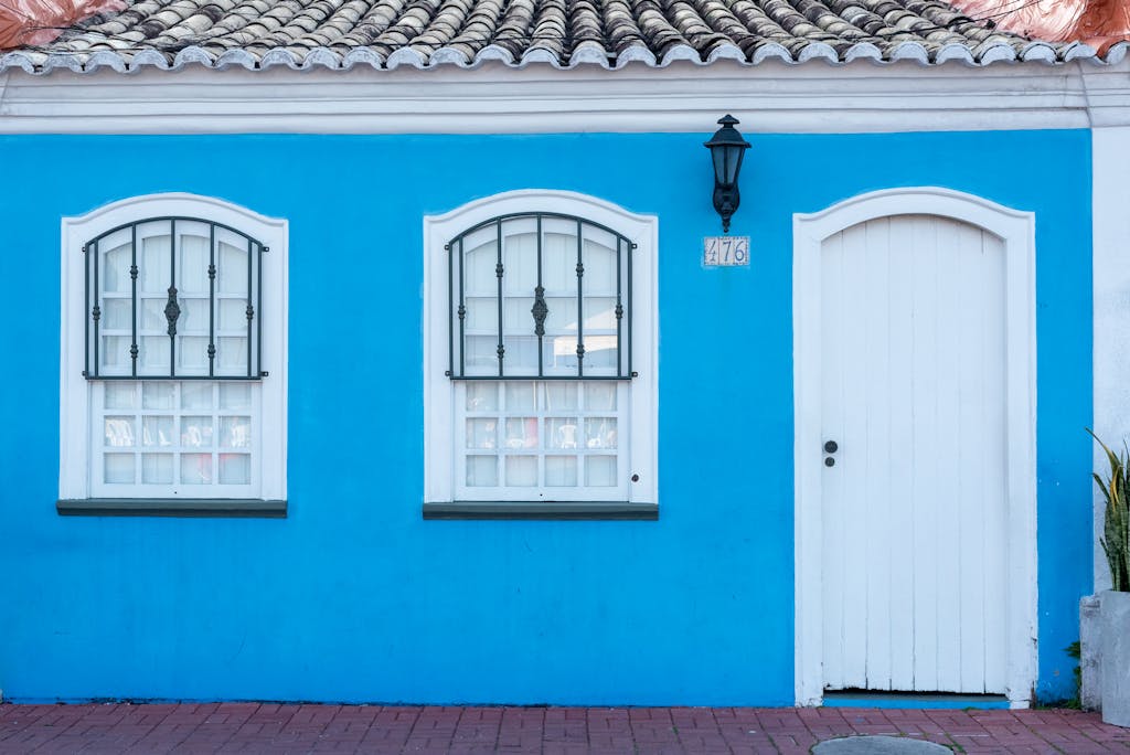 Dolfier Charming blue facade of a house in Porto Seguro, Brazil with traditional windows and door.