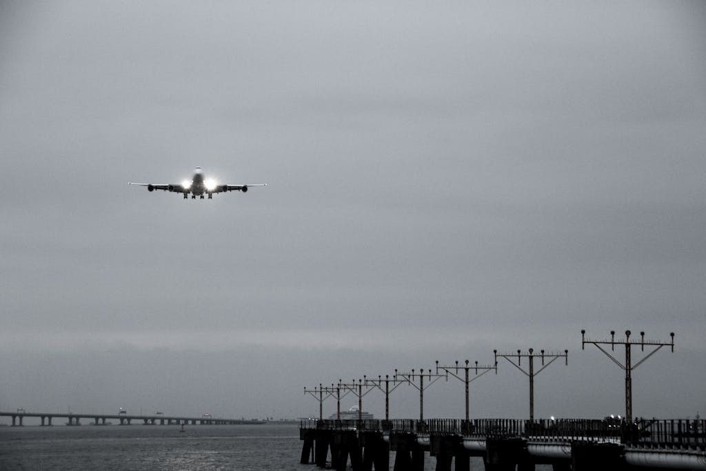 vrealize infrastructure navigator Grayscale image of an airplane landing over water with navigational lights near Hong Kong.