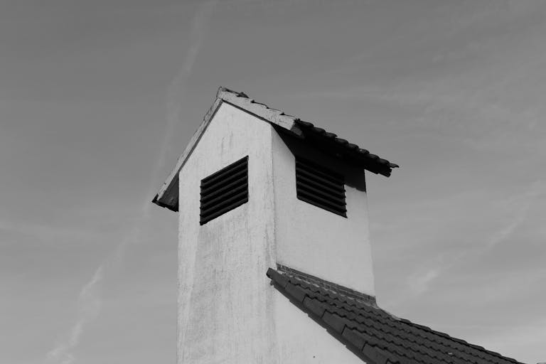 Permanent Monochrome image of a building's rooftop showcasing minimalist architecture against a clear sky.