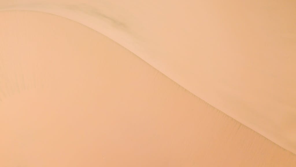 Ibomma1.com Smooth aerial view of sand dunes creating a tranquil desert landscape.