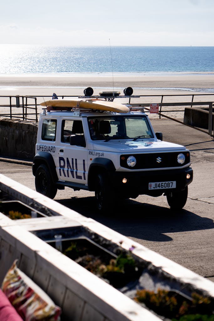 Kongotech org A lifeguard vehicle patrols a sunny beach. Perfect for summer travel and safety themes.